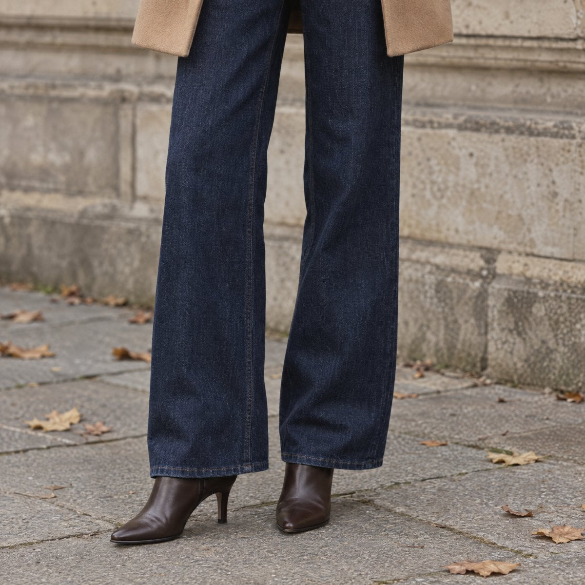 Jean large indigo et bottines en cuir brun sur des pavés parisiens