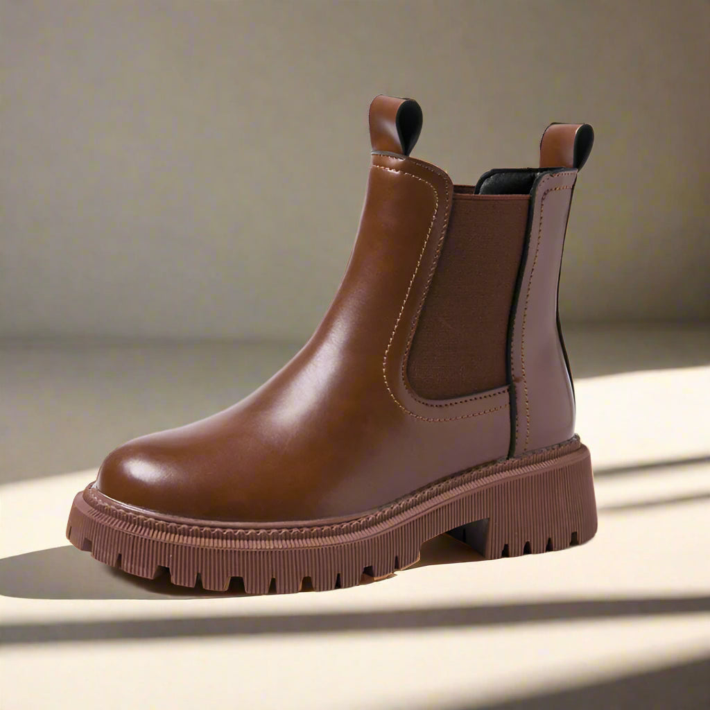 Brown leather Chelsea boot on a light background