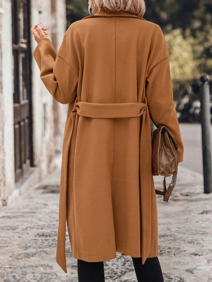 a woman wearing a caramel coat with a back view 