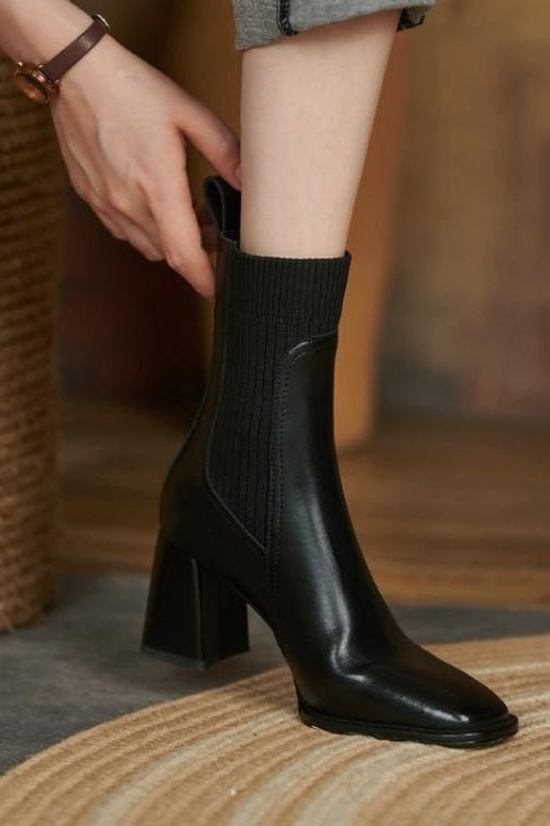 Person wearing a black sock boot on a blurred indoor background