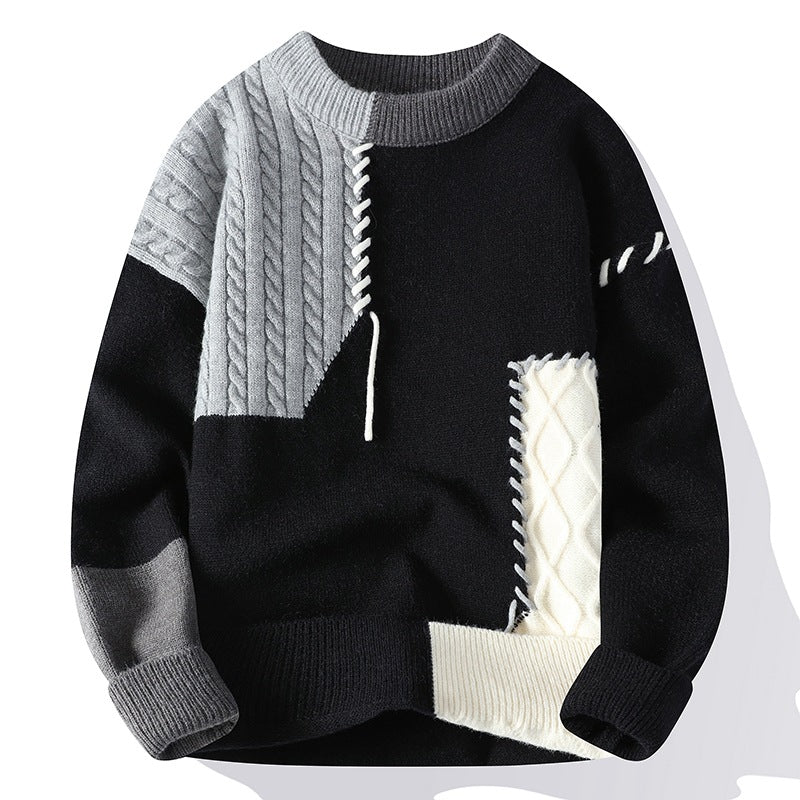 Black, gray, and white sweater with cable knit details on a white background