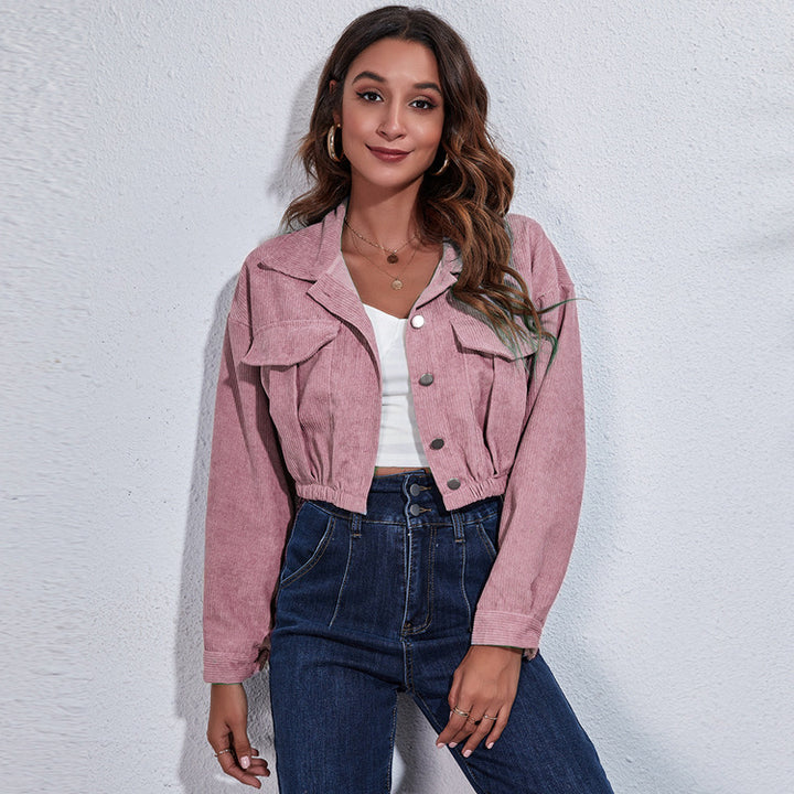 Woman wearing a pink jacket and blue jeans against a white background