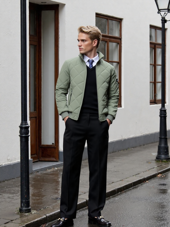 Man wearing a green quilted jacket over a dark outfit on a city street.