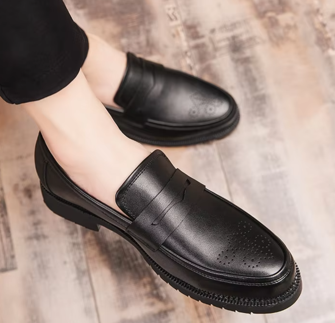 Black leather shoes worn on a wooden floor