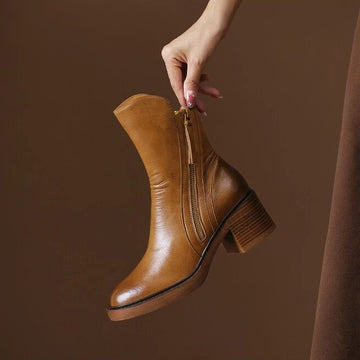 Botte Capucine cognac tenue à la main, double zip sur le côté