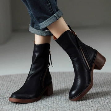 Paire de bottes Capucine noires portées avec un jean