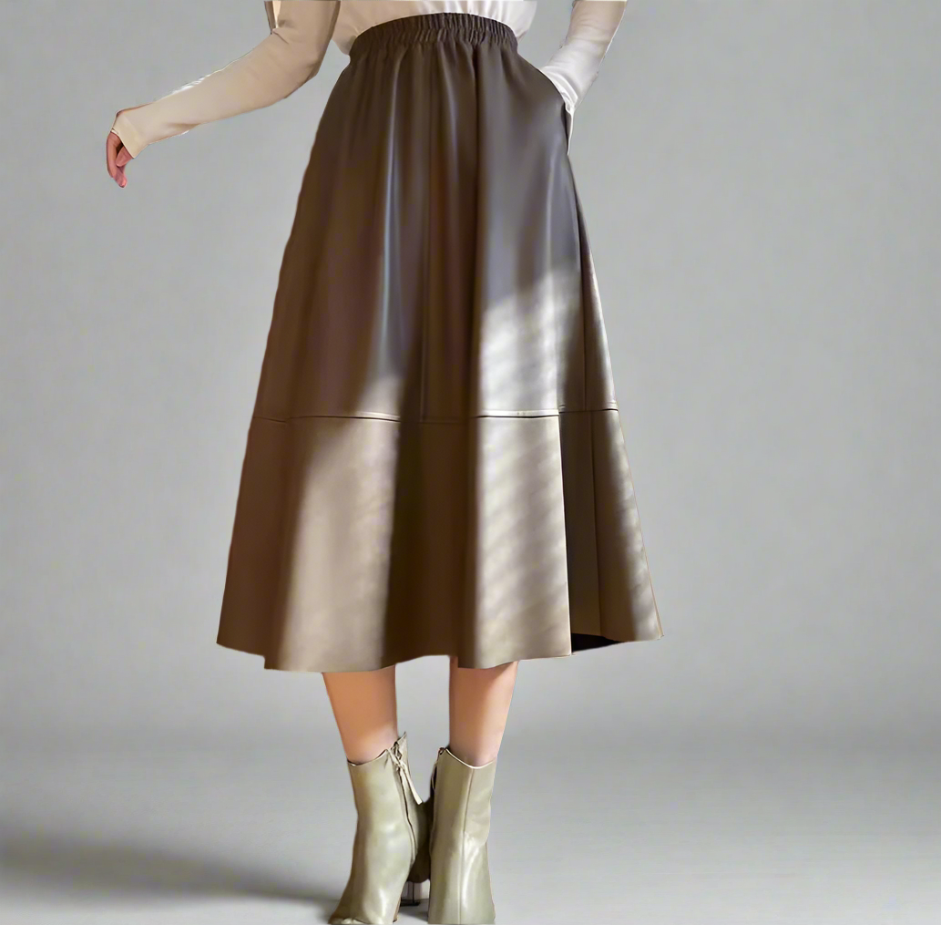 Brown leather skirt worn by a person on a gray background