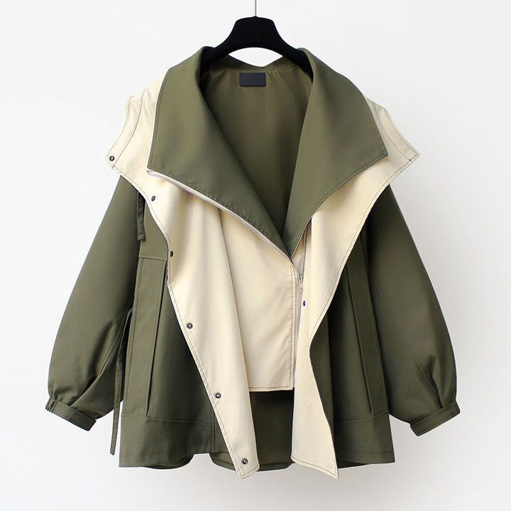 Green and beige jacket on a hanger against a white background