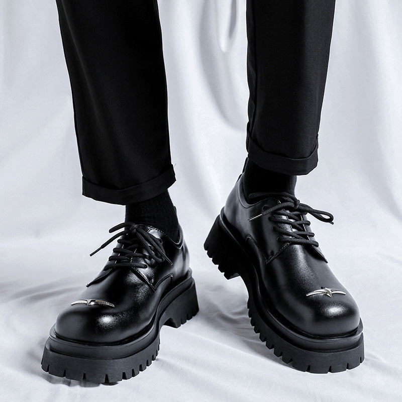 Black leather shoes worn with black pants on a white background