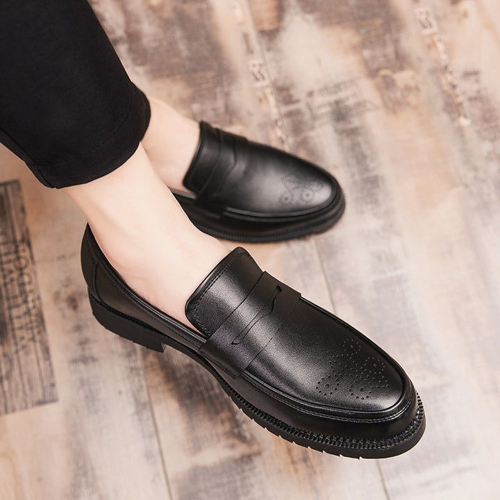 Black leather shoes worn on a wooden floor