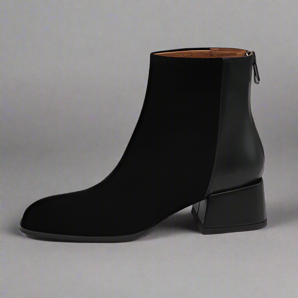 Black ankle boot on a gray background